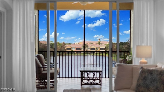 sunroom with a water view and ceiling fan