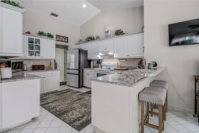 603 Canton Ave, Lehigh Acres, FL 33972 - kitchen featuring stainless steel appliances, a peninsula, under cabinet range hood, white cabinetry, and high vaulted ceiling