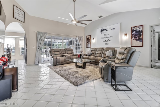 living room with ceiling fan, light tile patterned floors, and vaulted ceiling