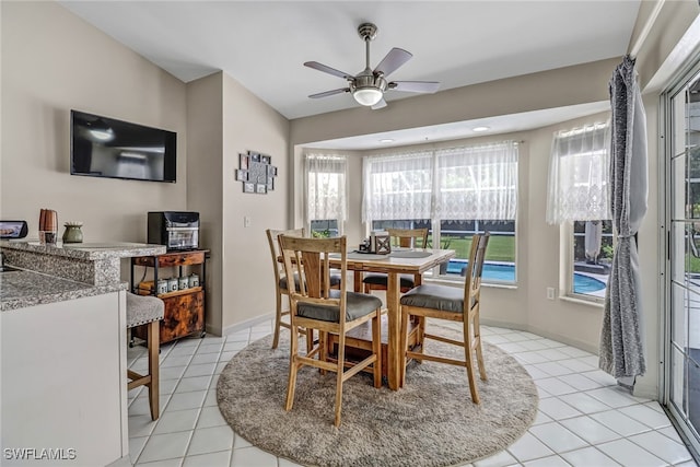 tiled dining space featuring ceiling fan