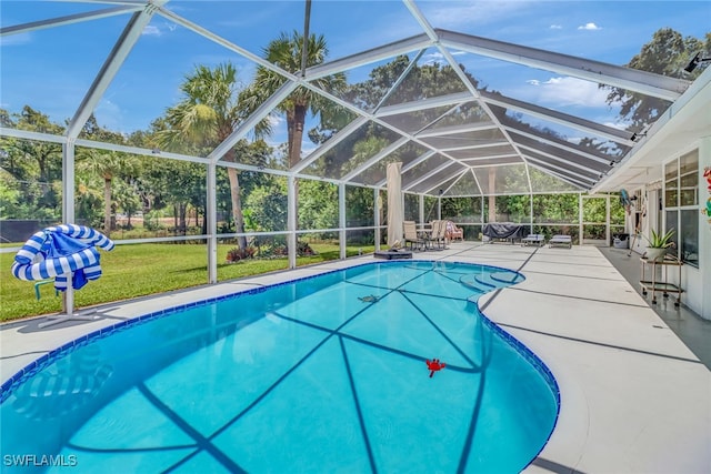 view of swimming pool featuring glass enclosure, a yard, and a patio area