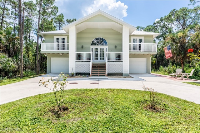 beach home with french doors, a garage, a porch, and a front yard