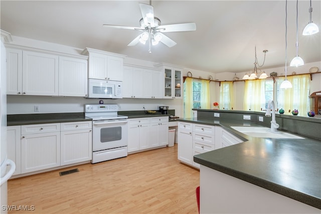 kitchen featuring pendant lighting, white cabinetry, white appliances, and sink