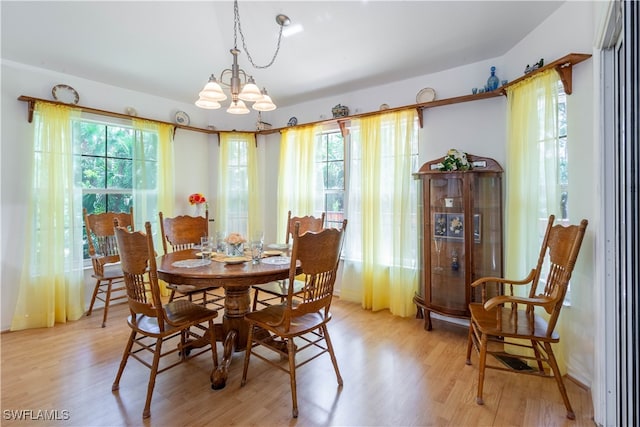 dining space with a chandelier and light hardwood / wood-style flooring