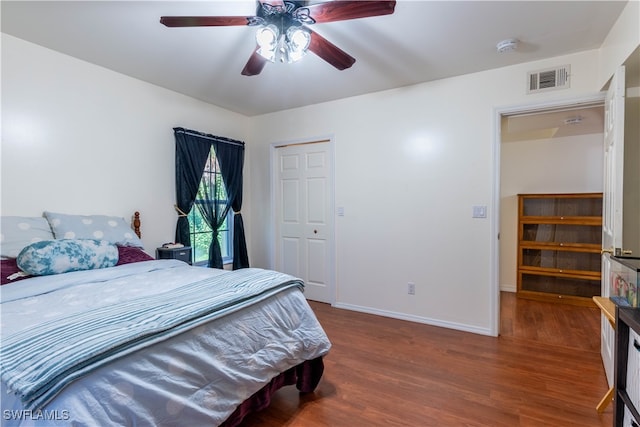 bedroom with a closet, hardwood / wood-style flooring, and ceiling fan