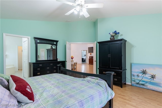 bedroom with ceiling fan, ensuite bath, light wood-type flooring, and lofted ceiling