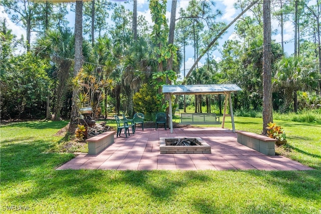 view of community with an outdoor fire pit, a yard, and a patio area