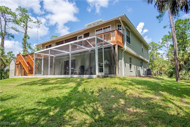 rear view of house featuring central AC unit, a lawn, and a sunroom