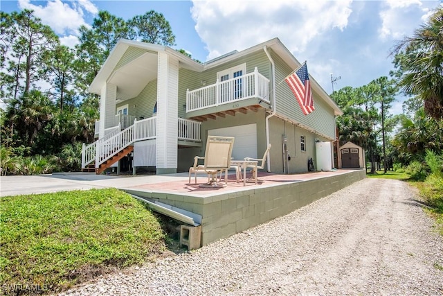430 Shady Hollow Blvd E, Naples, FL 34120 - back of house with a storage shed, an outbuilding, stairs, and an attached garage