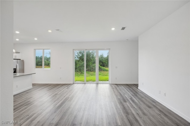 unfurnished living room with plenty of natural light and light hardwood / wood-style flooring