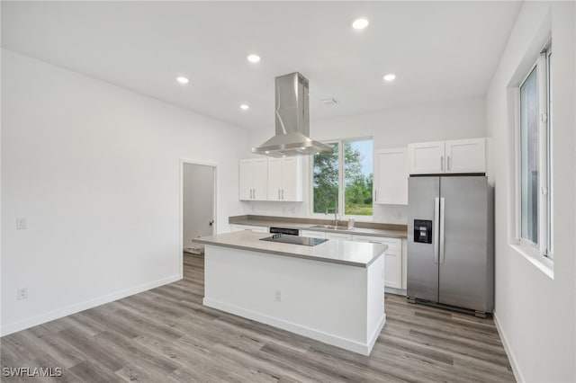 kitchen featuring island exhaust hood, stainless steel fridge, a kitchen island, light hardwood / wood-style floors, and white cabinetry