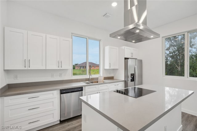 kitchen featuring white cabinets, dark hardwood / wood-style floors, a kitchen island, island range hood, and stainless steel appliances