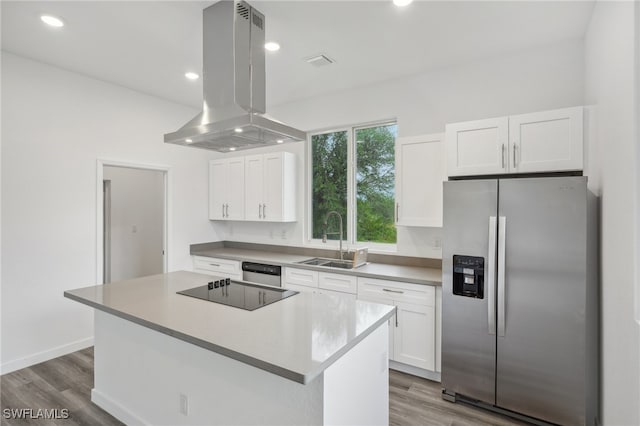 kitchen featuring island exhaust hood, appliances with stainless steel finishes, sink, white cabinets, and a center island