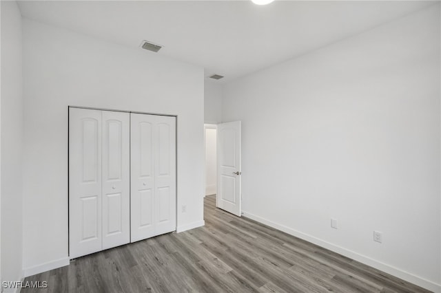 unfurnished bedroom featuring a closet and wood-type flooring