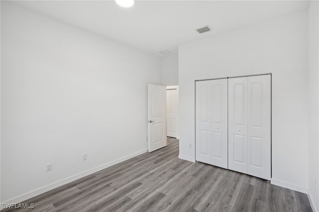 unfurnished bedroom featuring a closet and light hardwood / wood-style flooring