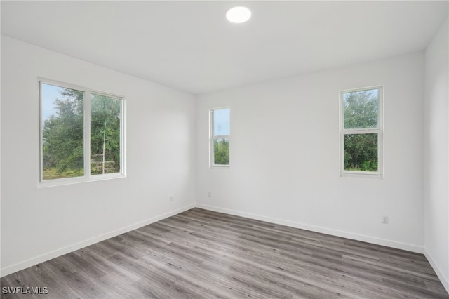 unfurnished room featuring hardwood / wood-style flooring and plenty of natural light