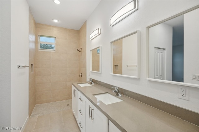 bathroom featuring tile patterned flooring, vanity, and tiled shower