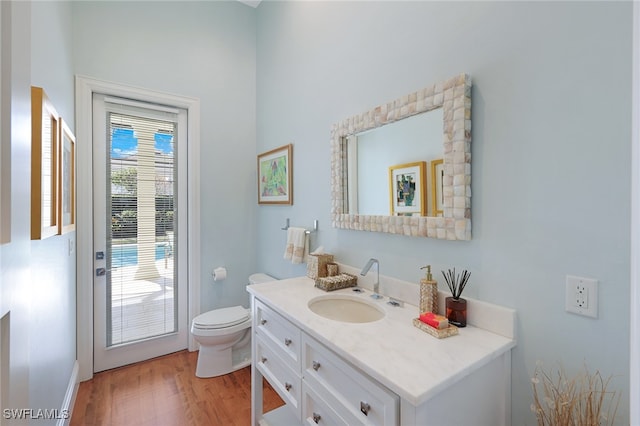 bathroom with hardwood / wood-style floors, vanity, and toilet