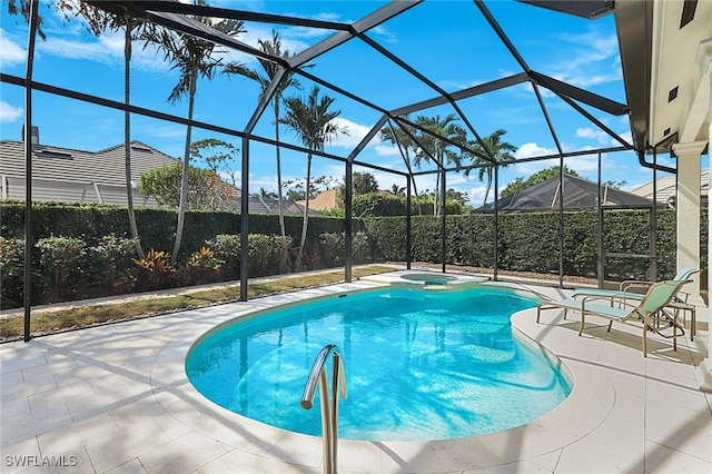 view of swimming pool featuring glass enclosure and a patio area