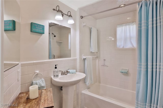 bathroom with shower / tub combo with curtain and tile walls