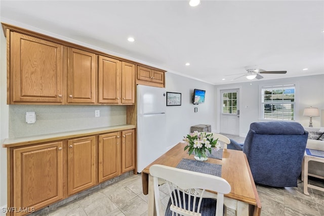 kitchen featuring ceiling fan, white fridge, backsplash, and ornamental molding