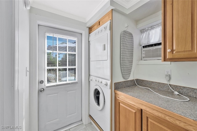 laundry room with stacked washer and clothes dryer, cooling unit, light tile patterned floors, and crown molding