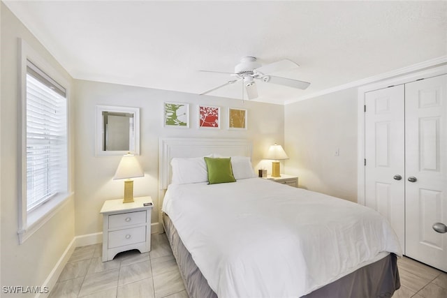 bedroom featuring a closet, light tile patterned floors, ceiling fan, and crown molding