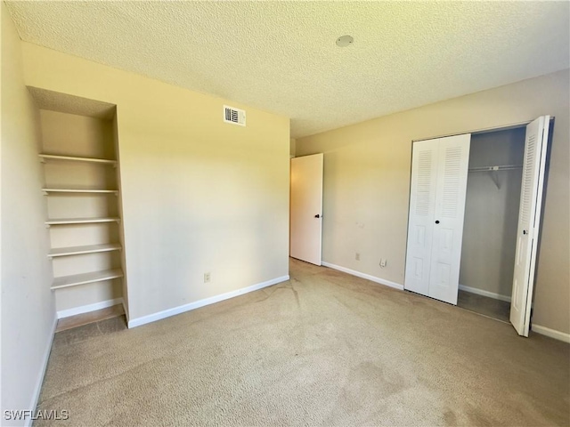 unfurnished bedroom with a textured ceiling and carpet floors