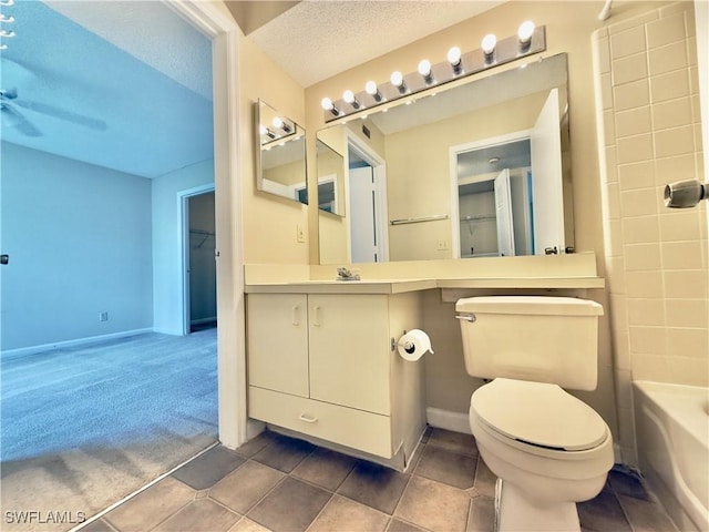 bathroom featuring tile patterned floors, vanity, a textured ceiling, and toilet