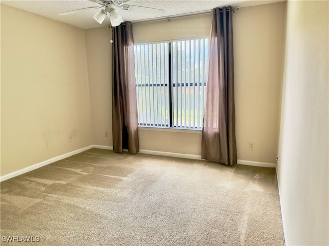 carpeted spare room with ceiling fan and a textured ceiling