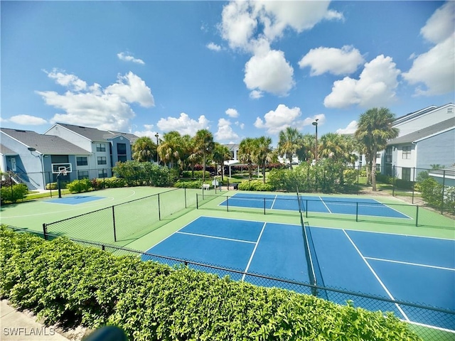 view of sport court with a residential view and fence