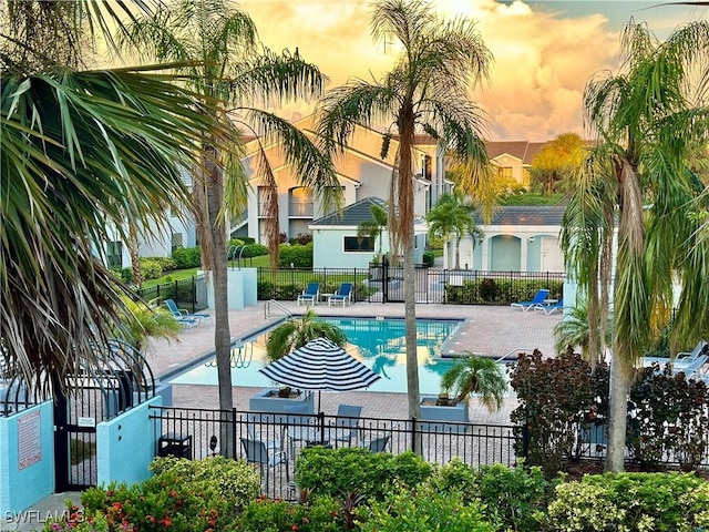 pool at dusk featuring a patio