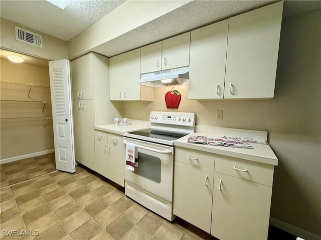 kitchen featuring light countertops, under cabinet range hood, visible vents, and electric range