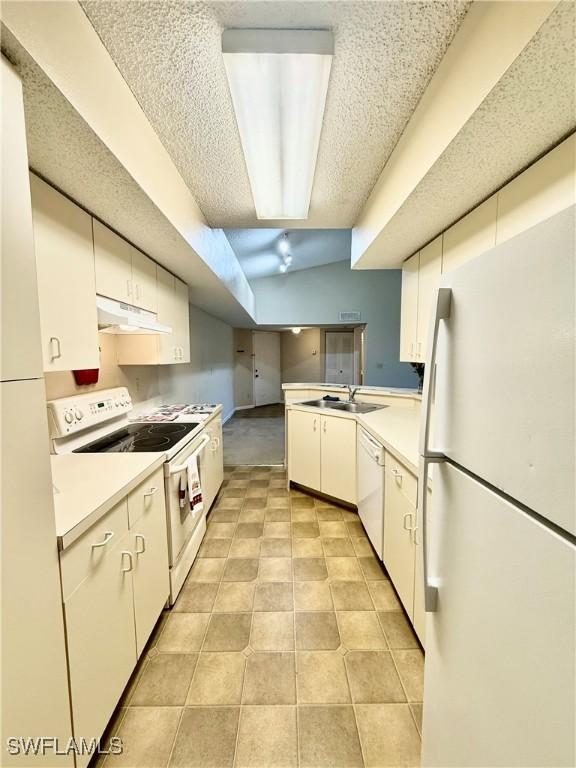 kitchen with white cabinets, a textured ceiling, white appliances, and sink