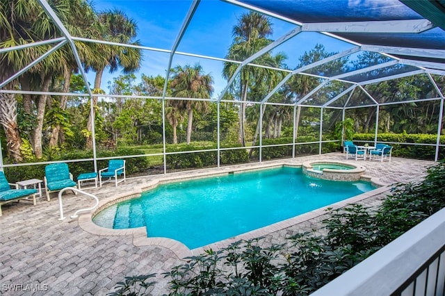 view of swimming pool with a patio, a lanai, and an in ground hot tub