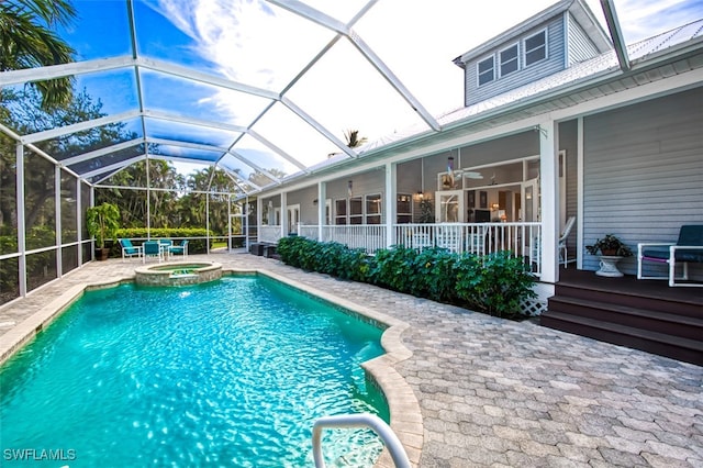 view of pool with a lanai, ceiling fan, an in ground hot tub, and a patio area