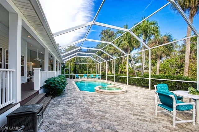 view of pool featuring a lanai, ceiling fan, a patio, and an in ground hot tub