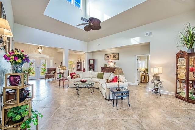 living room featuring a towering ceiling, ceiling fan, and french doors