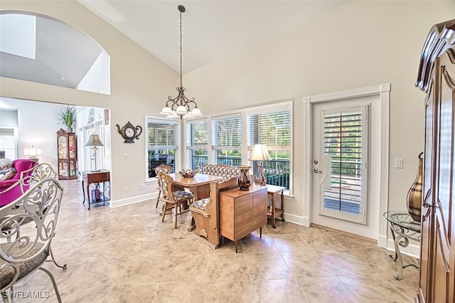 dining space featuring an inviting chandelier and high vaulted ceiling