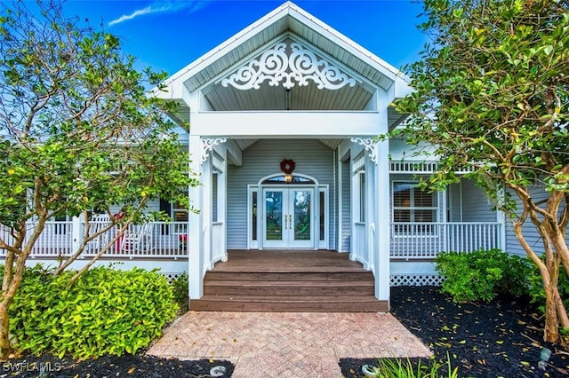 doorway to property featuring covered porch and french doors