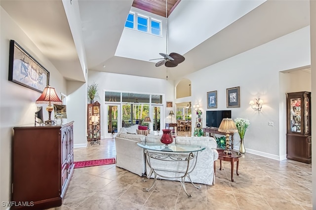 living room featuring a towering ceiling and ceiling fan