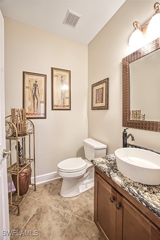 bathroom with tile patterned flooring, vanity, and toilet