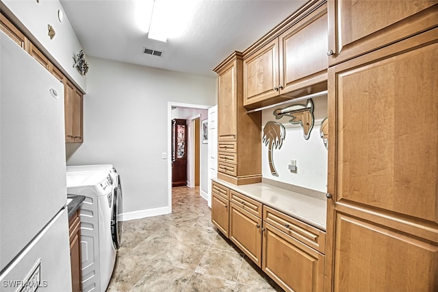 laundry room featuring washing machine and dryer and cabinets