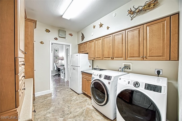 washroom with sink, cabinets, and independent washer and dryer