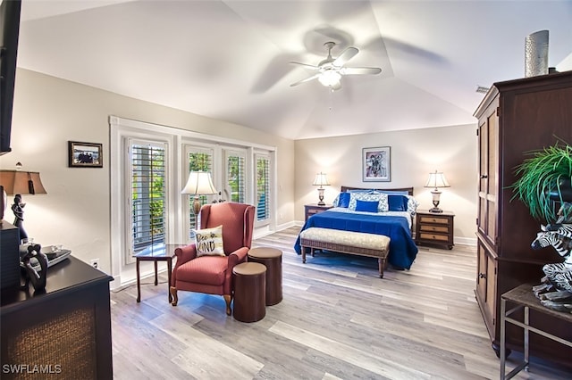 bedroom featuring light hardwood / wood-style floors, vaulted ceiling, and ceiling fan