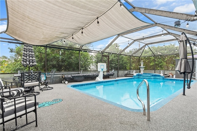 view of swimming pool featuring glass enclosure and a patio area