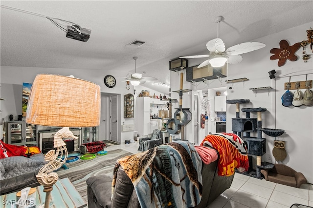 living room with light tile patterned flooring, ceiling fan, a textured ceiling, and vaulted ceiling