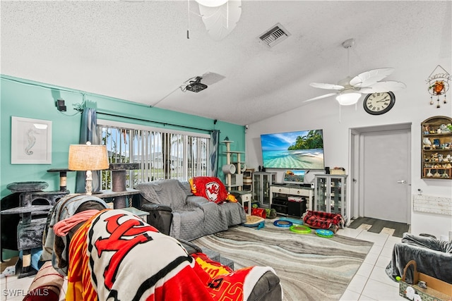 living room with a textured ceiling, lofted ceiling, ceiling fan, and light tile patterned flooring