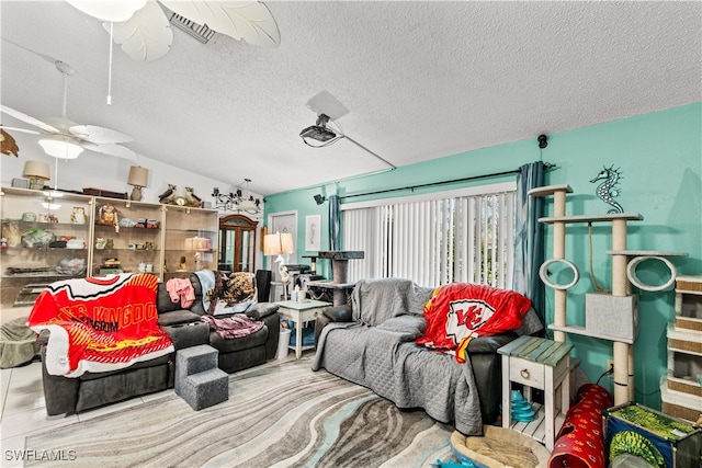 living room featuring a textured ceiling, lofted ceiling, and ceiling fan