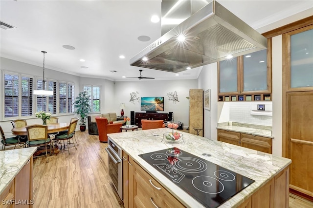 kitchen featuring island exhaust hood, crown molding, black electric stovetop, and ceiling fan